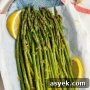This is a square picture of a plate filled with lemon garlic asparagus.