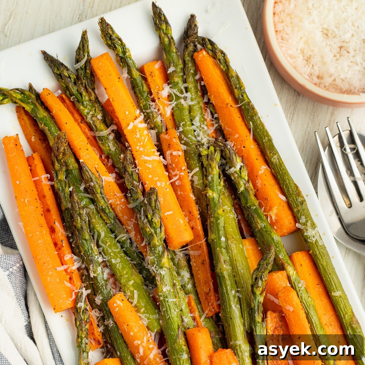 Square picture of roasted carrots and asparagus with parmesan.