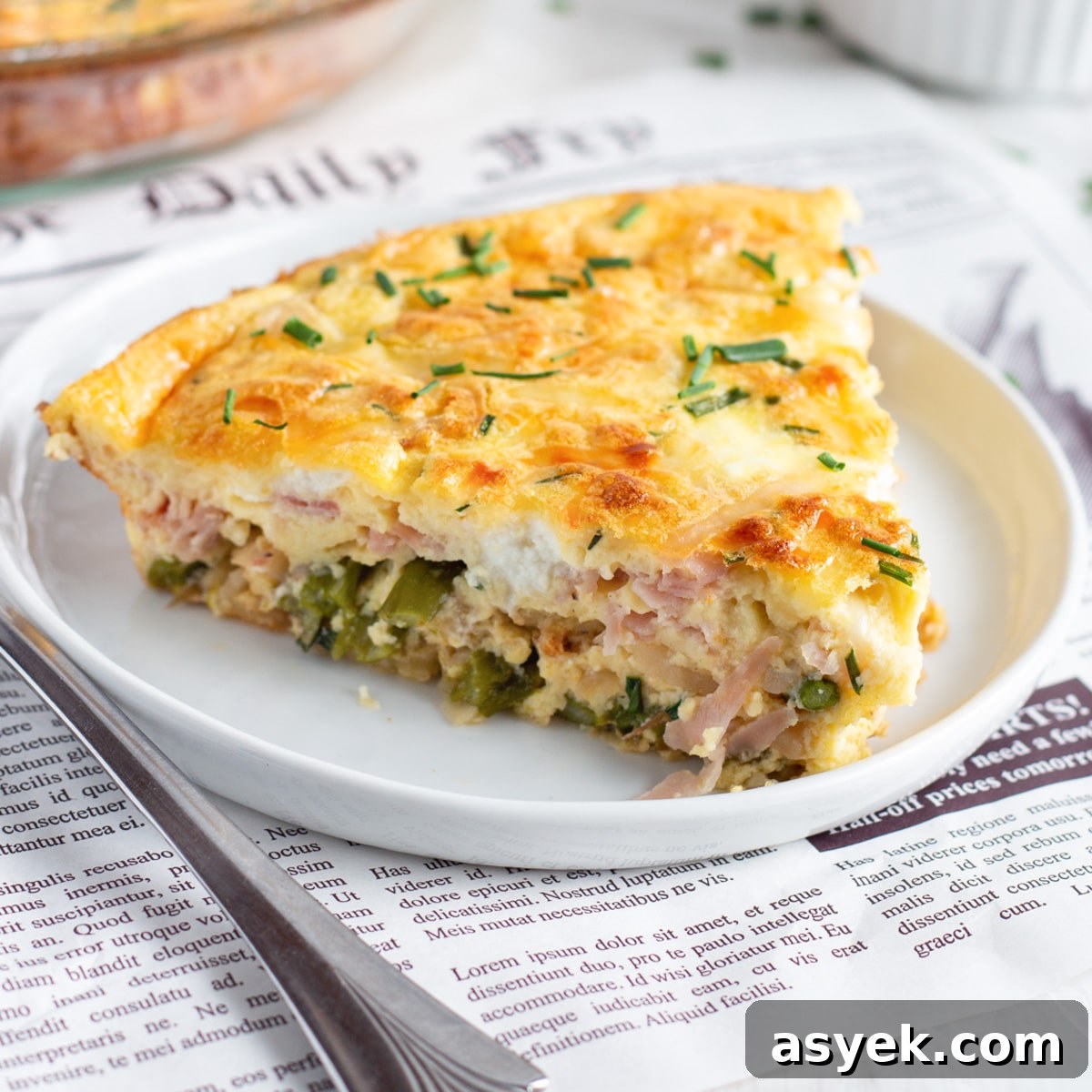This is a square picture of a slice of quiche.