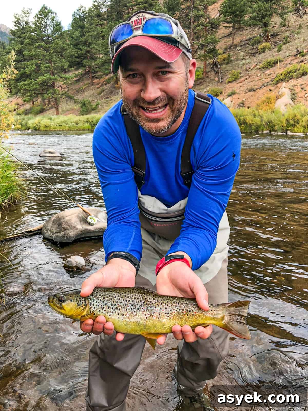 me standing in colorado river holding trout I caught