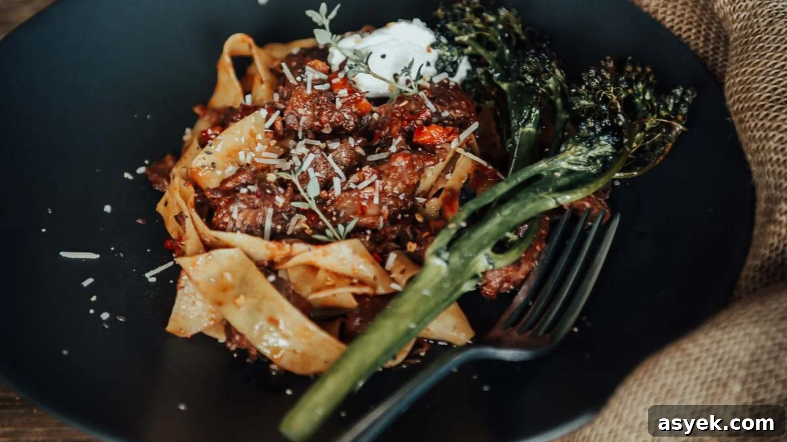 Osso buco with braised shanks in rich tomato sauce served with herbs on top.