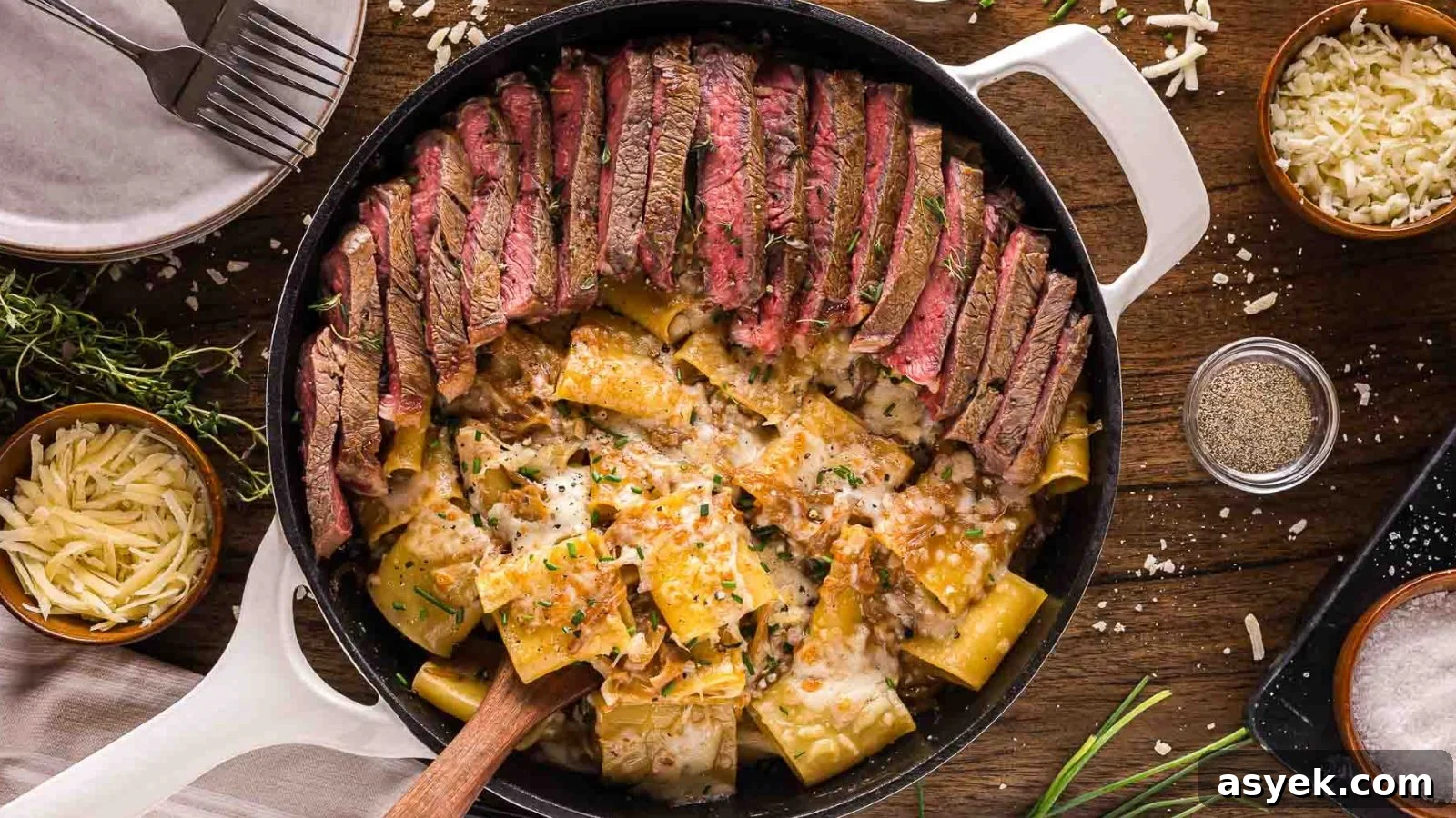 Creamy French onion pasta topped with sliced steak and caramelized onions in a deep bowl.