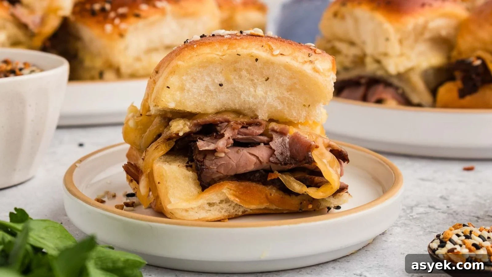 Roast beef sliders layered with horseradish sauce on toasted buns ready to serve.
