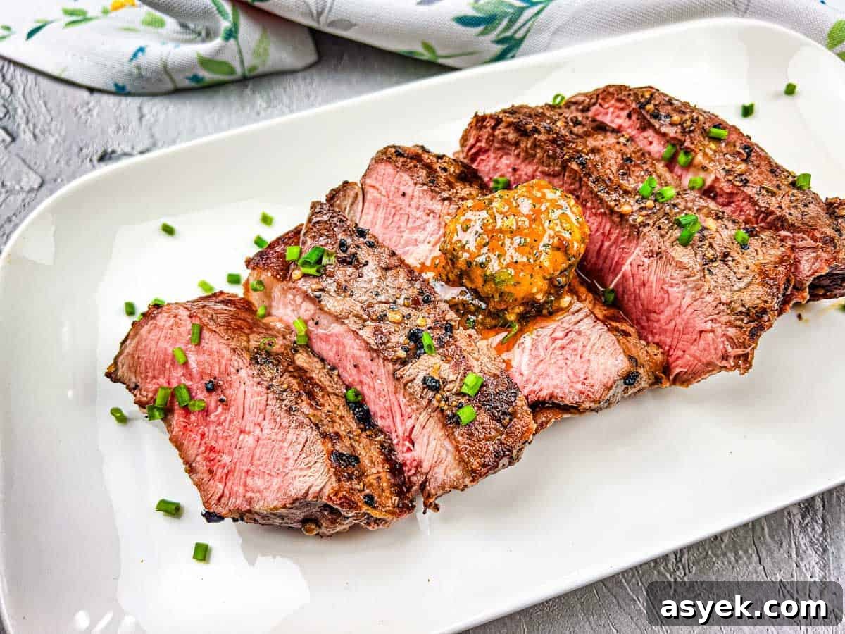 A grilled steak with cowboy butter on a white plate.