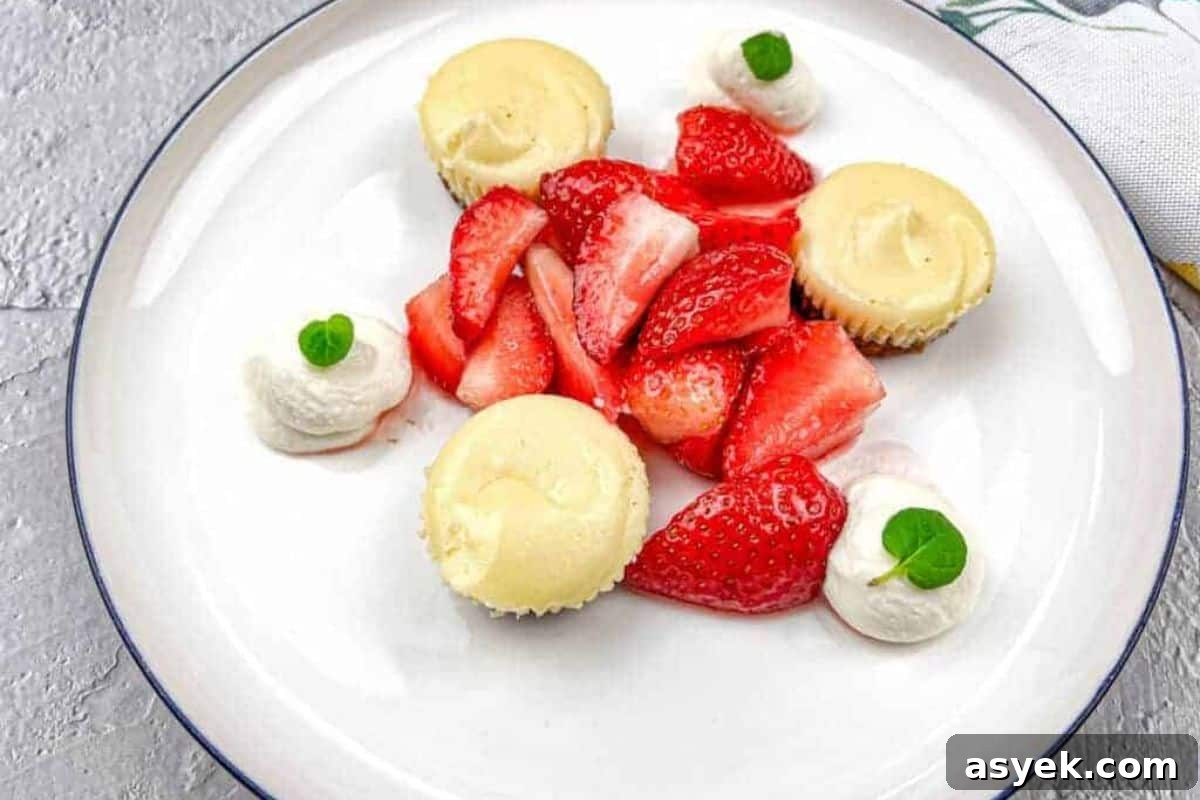 A white plate with strawberries and mini biscoff cheesecakes.