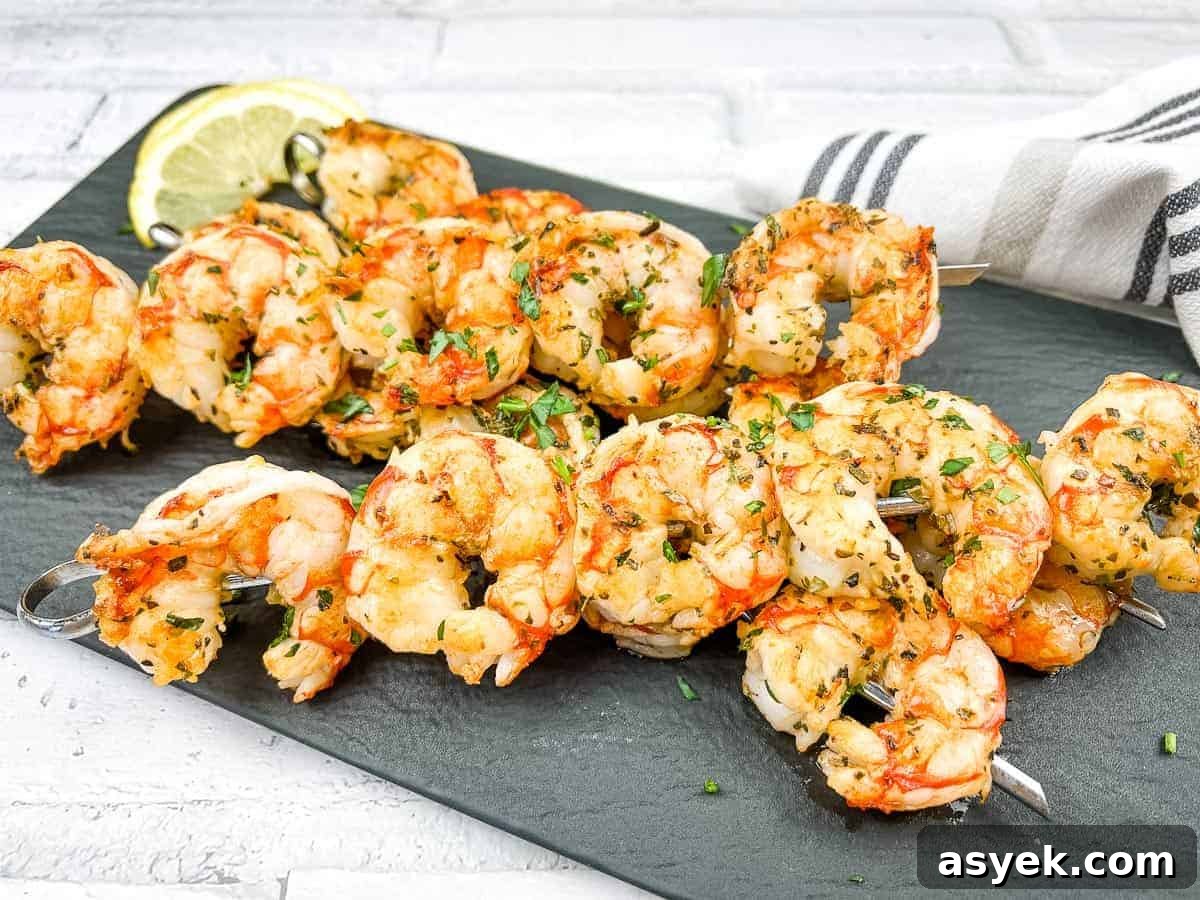 Mediterranean Grilled Shrimps on a white plate with lemon wedges.