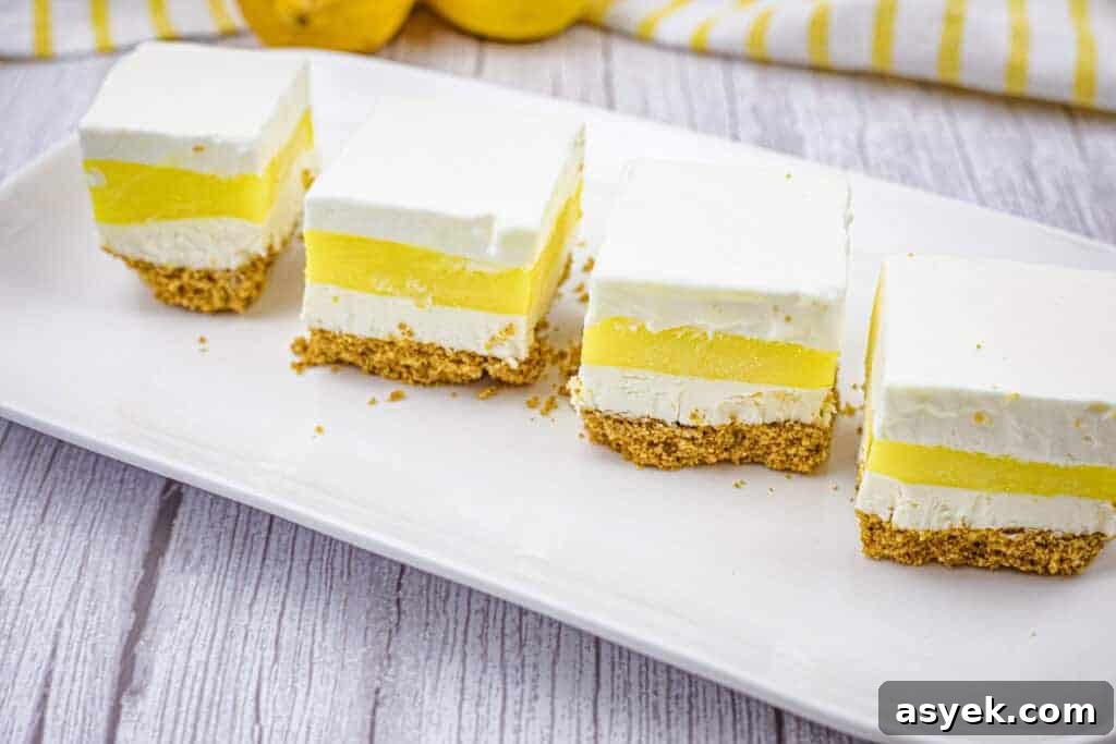 Four pieces of lemon lush on a white plate.