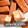 25+ Dairy-Free, Gluten-Free Protein Desserts 13 Chocolate coated Twix protein bars on a plate with one bar broken in half.