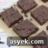 25+ Dairy-Free, Gluten-Free Protein Desserts 14 Dairy-free chocolate brownies drizzled with chocolate sauce on brown parchment paper with chocolate chips around them and a glass of milk with a blue linen to the side