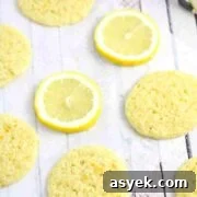 25+ Dairy-Free, Gluten-Free Protein Desserts 16 Thin dairy and gluten-free lemon cookies on parchment paper with lemons around them.