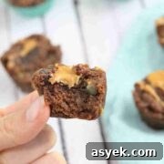 25+ Dairy-Free, Gluten-Free Protein Desserts 24 Two fingers placing a brownie on top of more chocolate protein brownies.