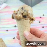 25+ Dairy-Free, Gluten-Free Protein Desserts 32 A chocolate swirled protein ice cream in an ice cream cone being held up close with a baking loaf of protein ice cream behind it.