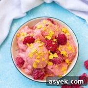 25+ Dairy-Free, Gluten-Free Protein Desserts 35 Raspberry protein frozen yogurt in a white bowl topped with cereal and a light linen behind it.