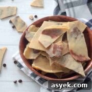 25+ Dairy-Free, Gluten-Free Protein Desserts 8 Peanut butter protein barks on a plate on top of a kitchen towel with chocolate chips and bark pieces around.