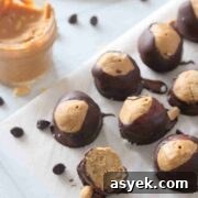 25+ Dairy-Free, Gluten-Free Protein Desserts 9 High protein peanut butter chocolate buckeyes on top of a parchment paper, with peanut butter on the side.