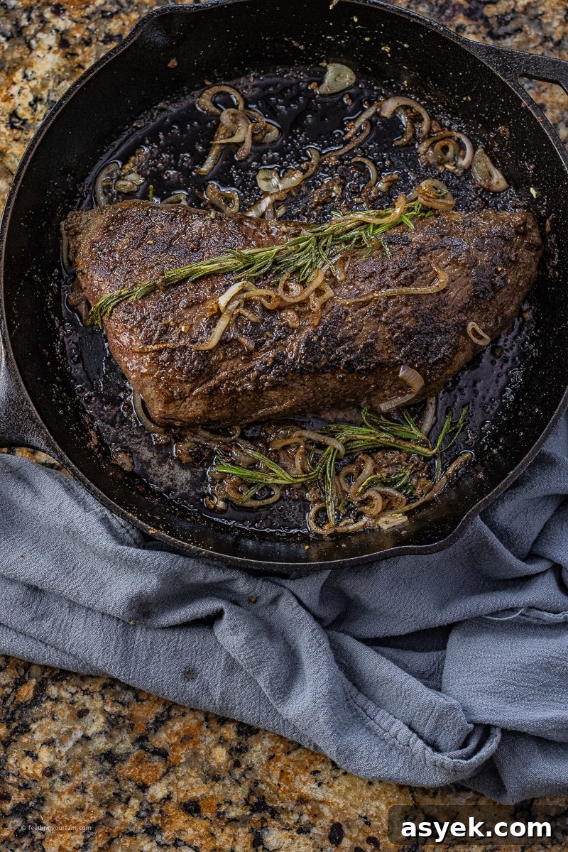 black cast iron pan with a tri tip cooked in it