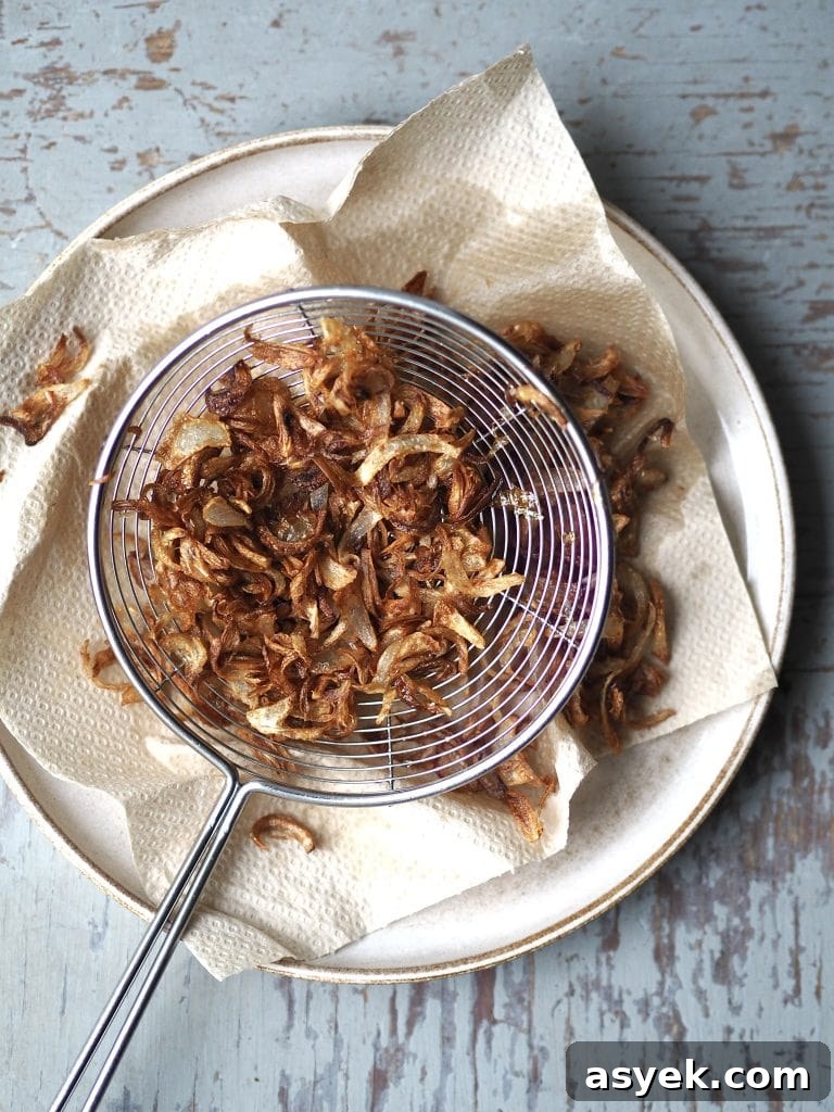 15-Minute Curry Udon Recipe with Tofu and Crispy Shallots 6 A plate with crispy shallots draining on kitchen paper.