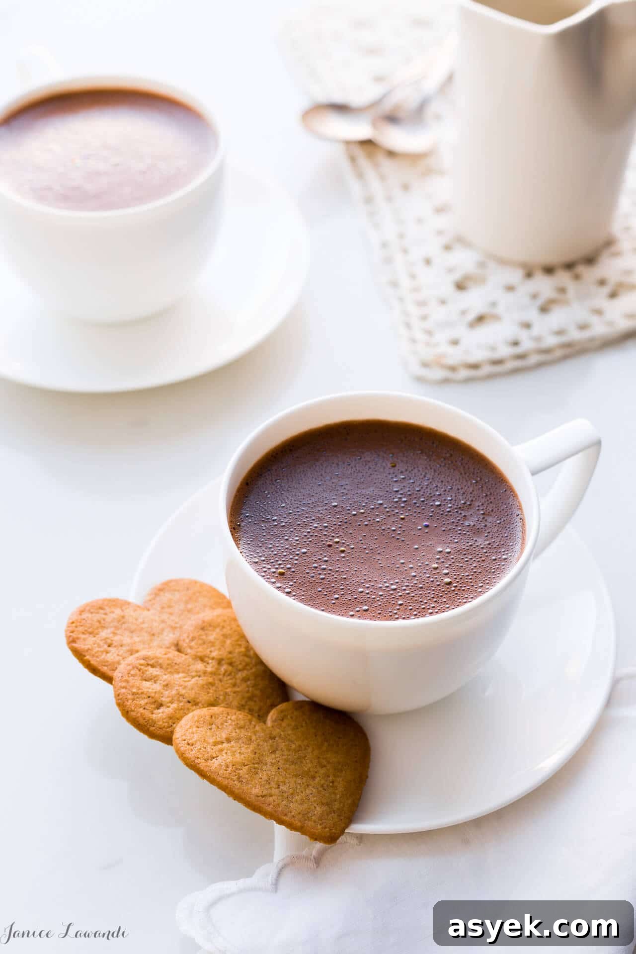 How to Make Earl Grey Hot Chocolate 2 Homemade hot chocolate served in white cups, white saucers, and heart-shaped cookies.
